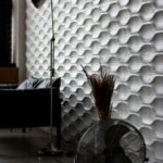 Contemporary office space featuring a unique 3D textured wall, stylish lamp, and fan.